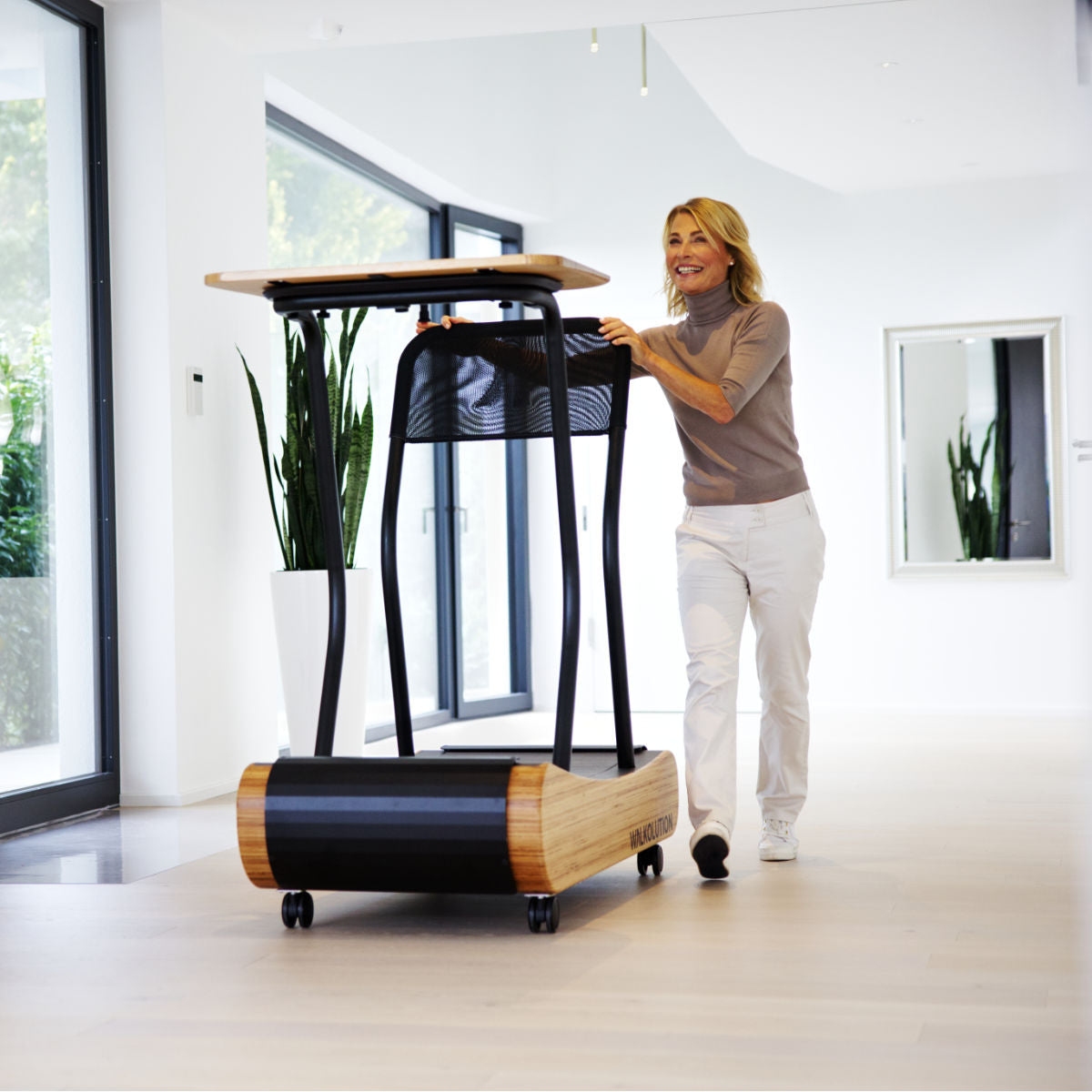 Woman pushes treadmill desk Walkolution Germany